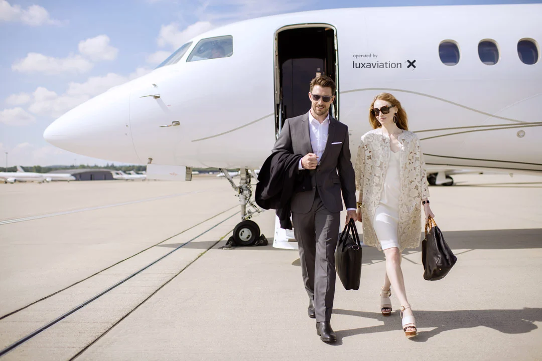 Passengers approaching a private jet on an executive airport ramp